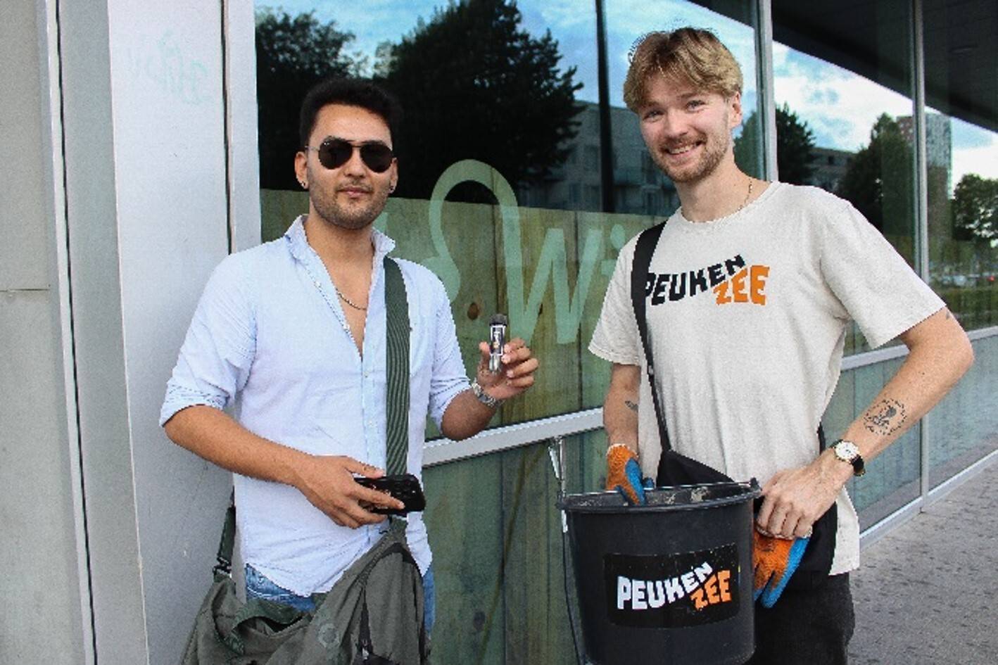 Twee jongens houden een zakasbak vast