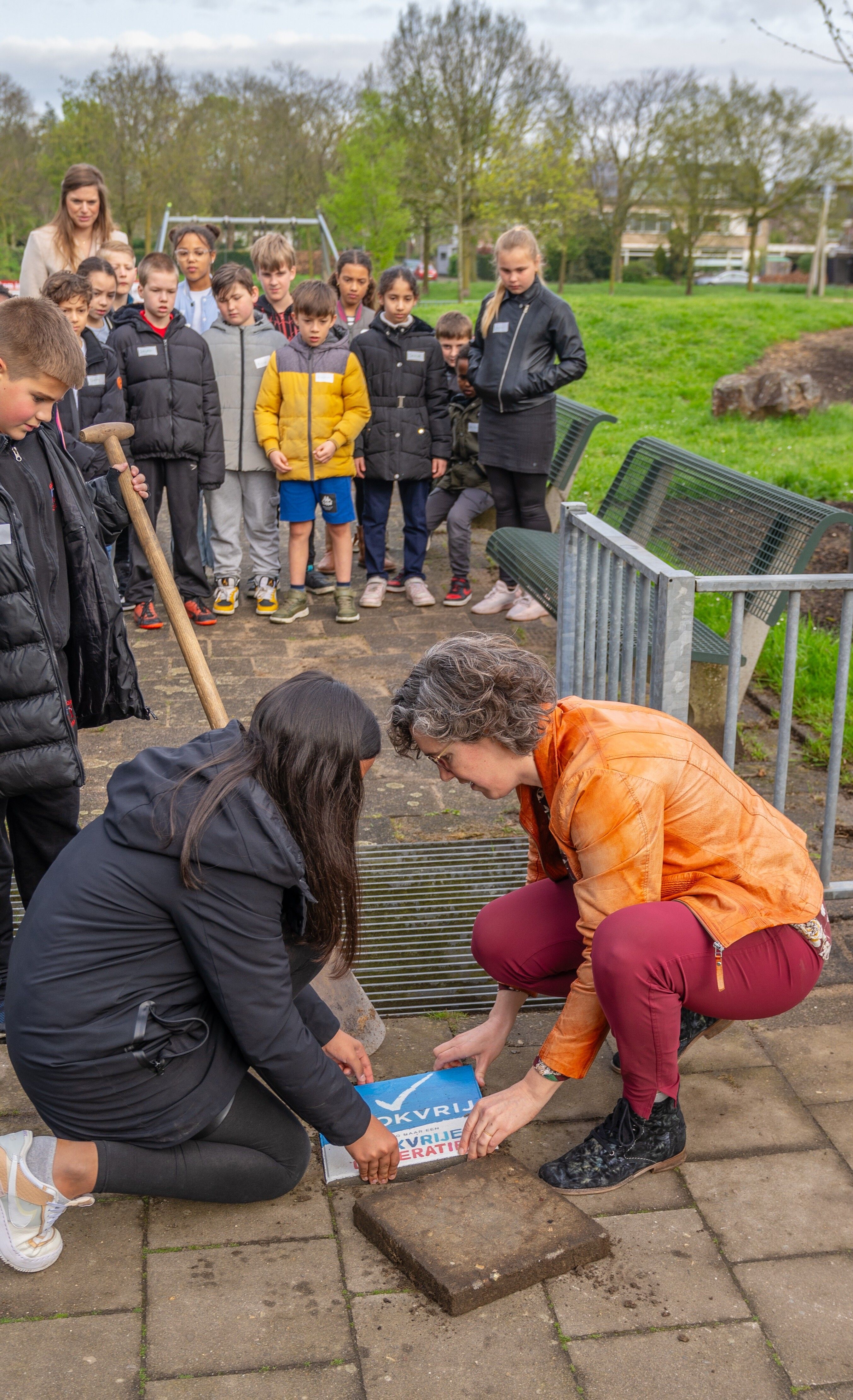 Wethouder legt samen met een van de kinderen de rookvrije tegel neer