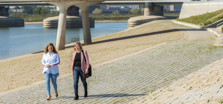 twee wandelende vrouwen langs de waalkade